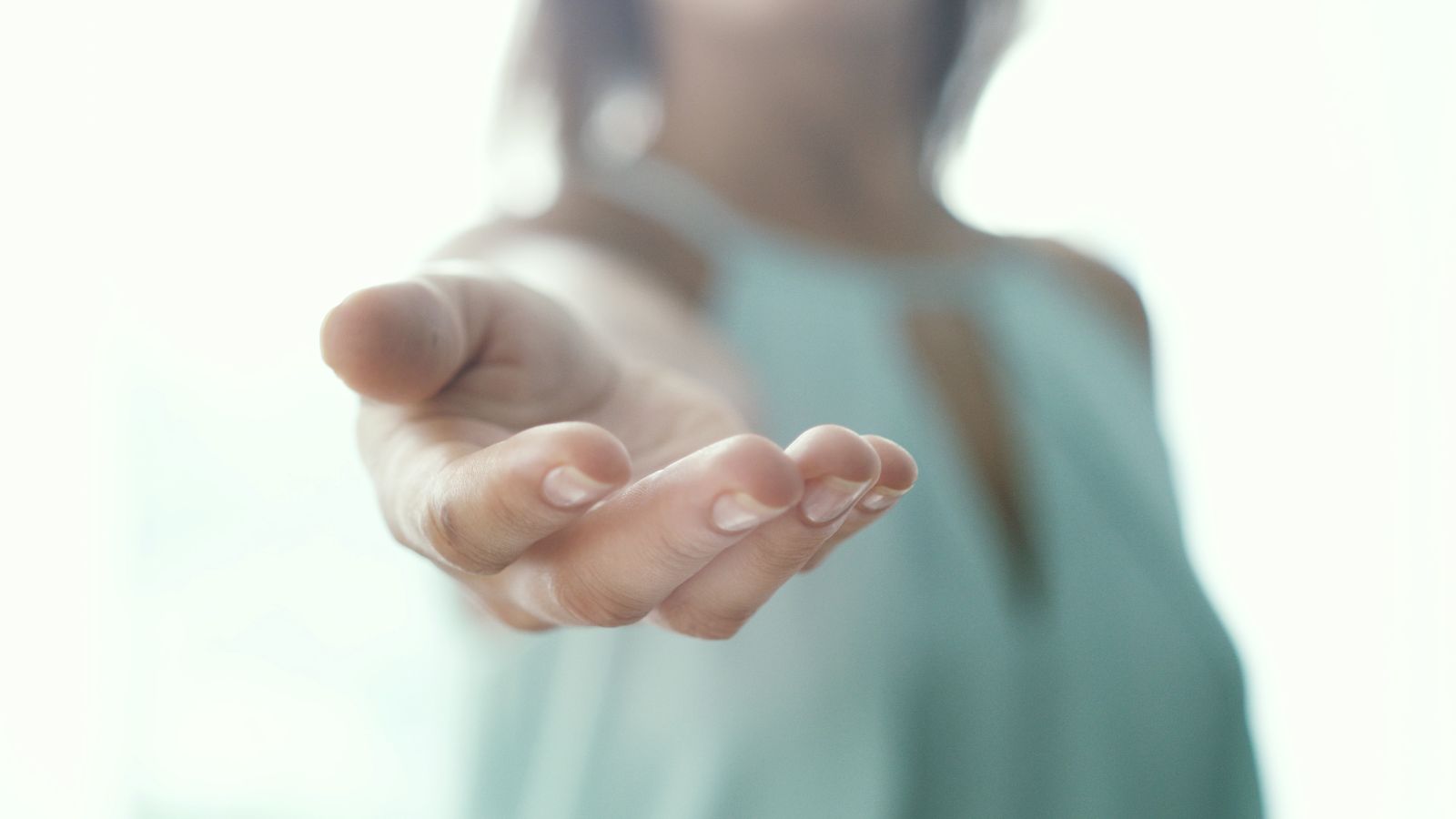 Blurred image of a woman extending a helping hand as a sponsor
